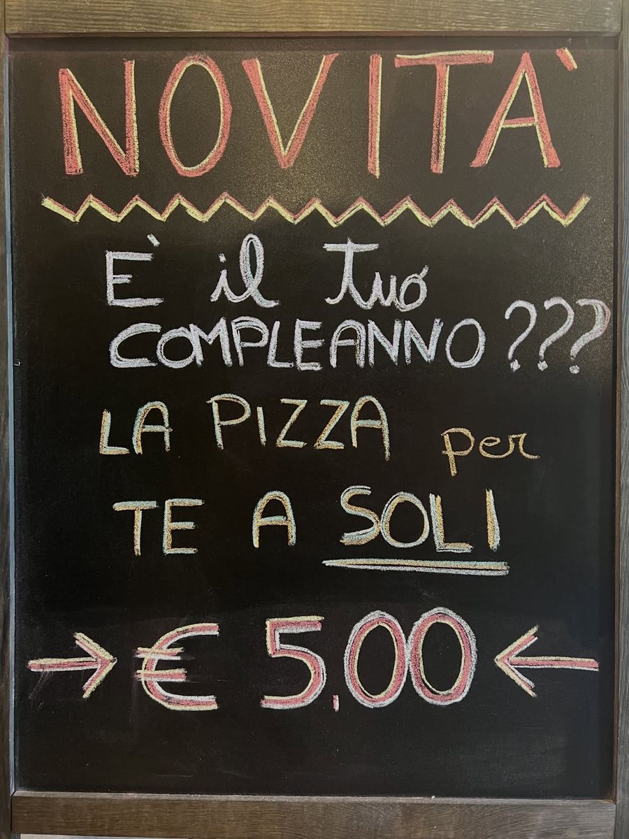 La lavagna del locale: «Novità! È il tuo compleanno? La pizza per te a soli 5,00 €»